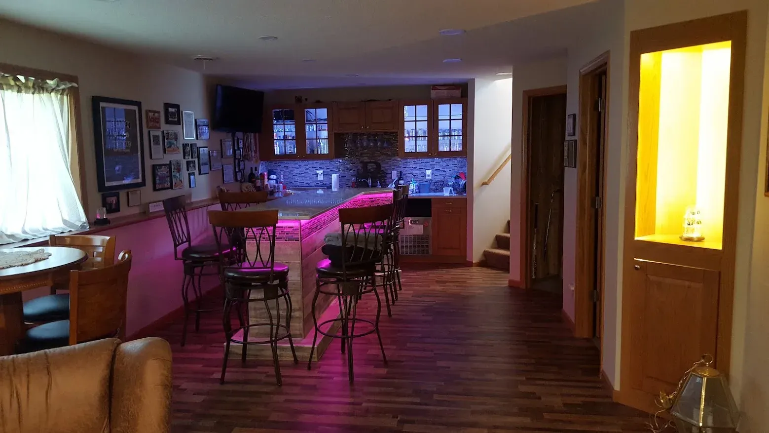 Finished custom tiled basement bar with seating and pendant lighting