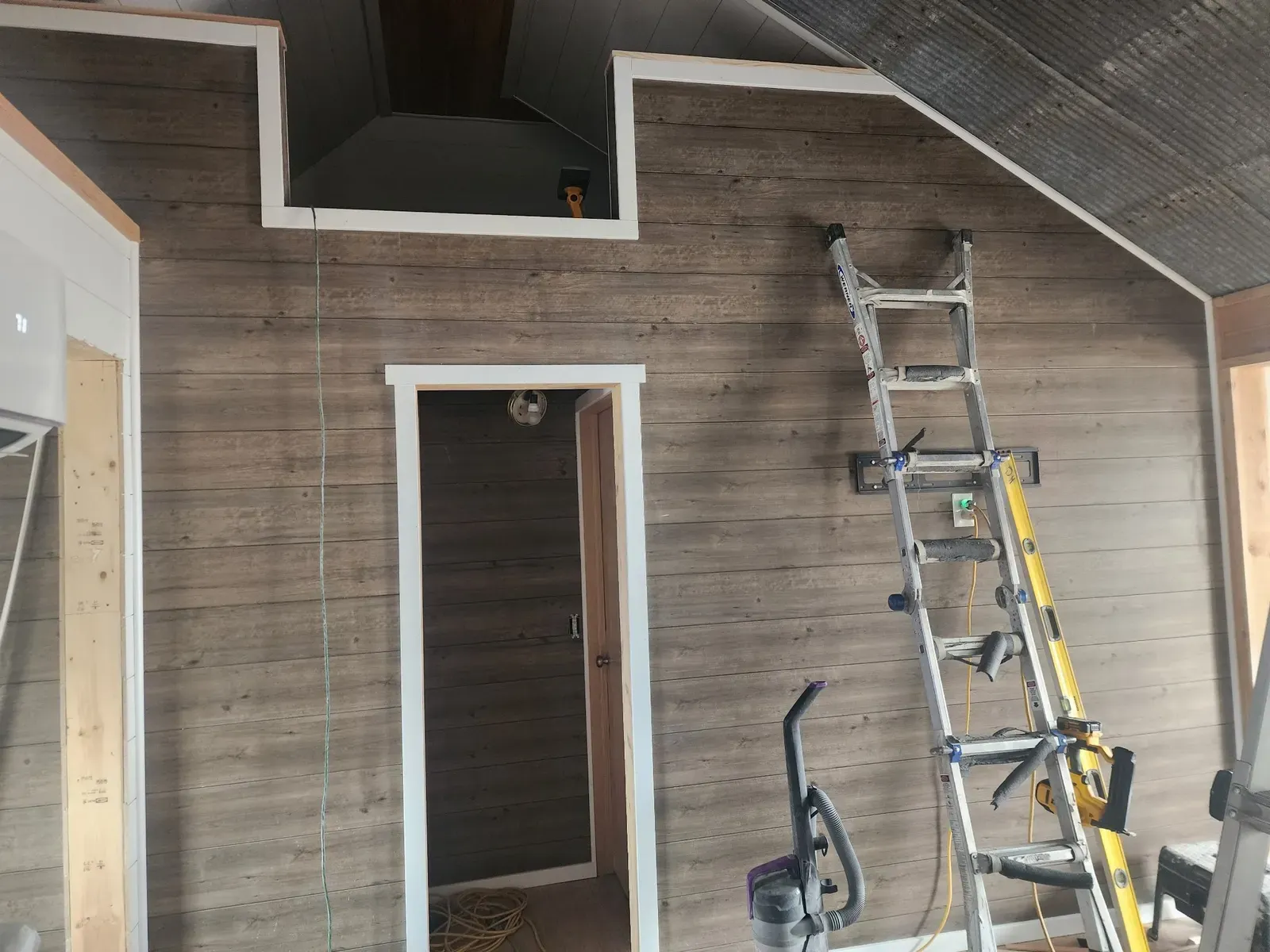 Living room wall paneling and trim during the cabin remodel
