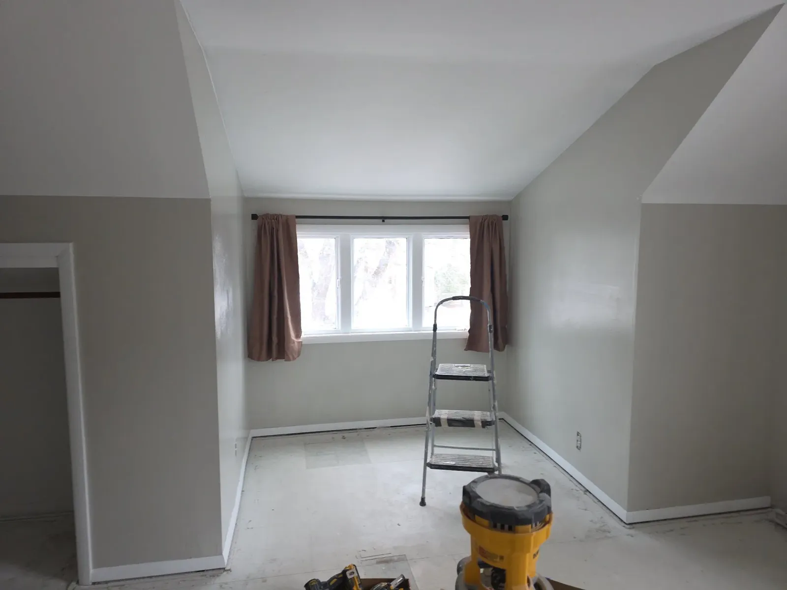 Bedroom nearing completion with fresh gray walls and white trim