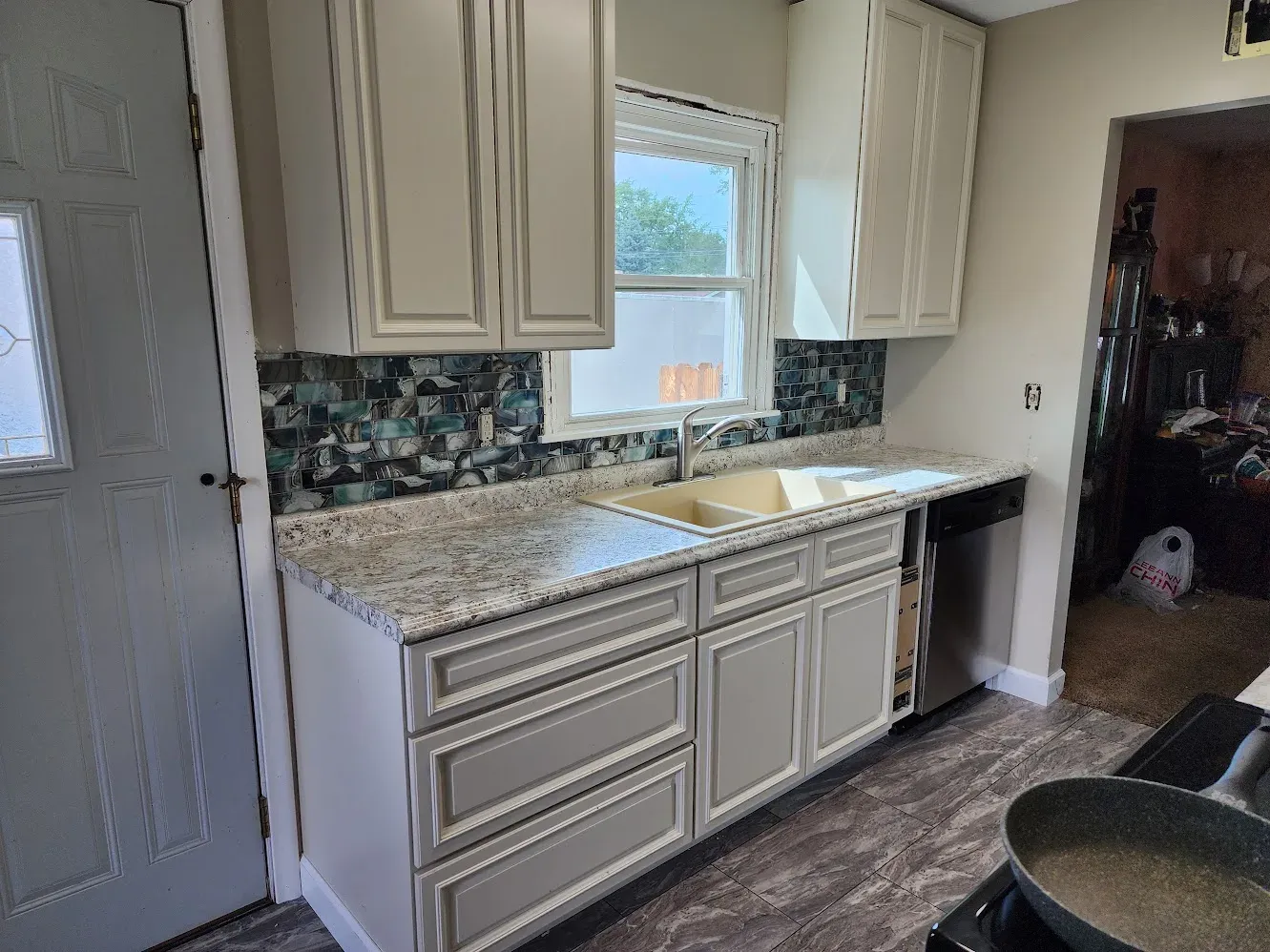 Finished kitchen with new cabinets, counters, flooring, and mosaic backsplash