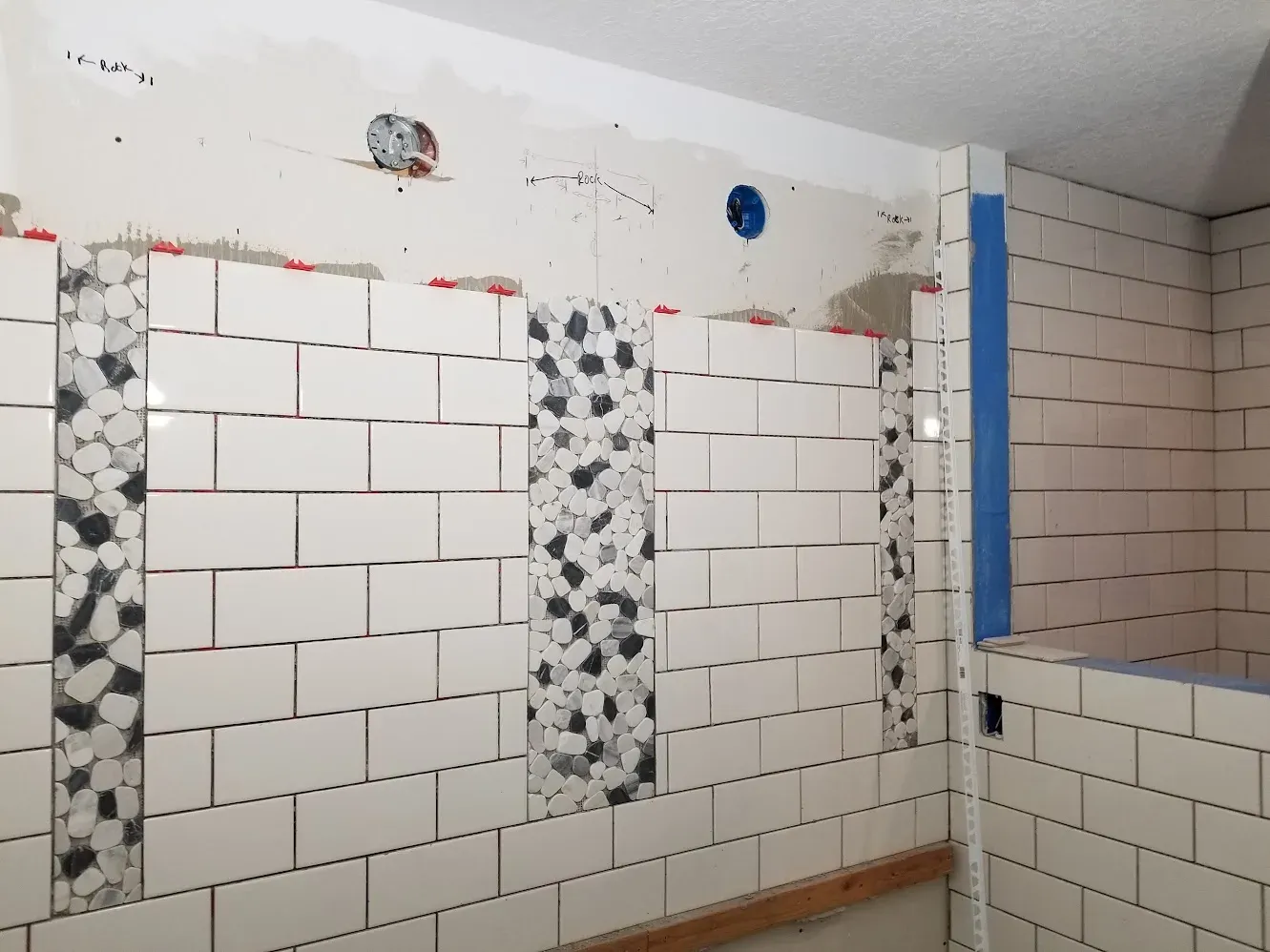 Walk-in shower walls midway through tile installation