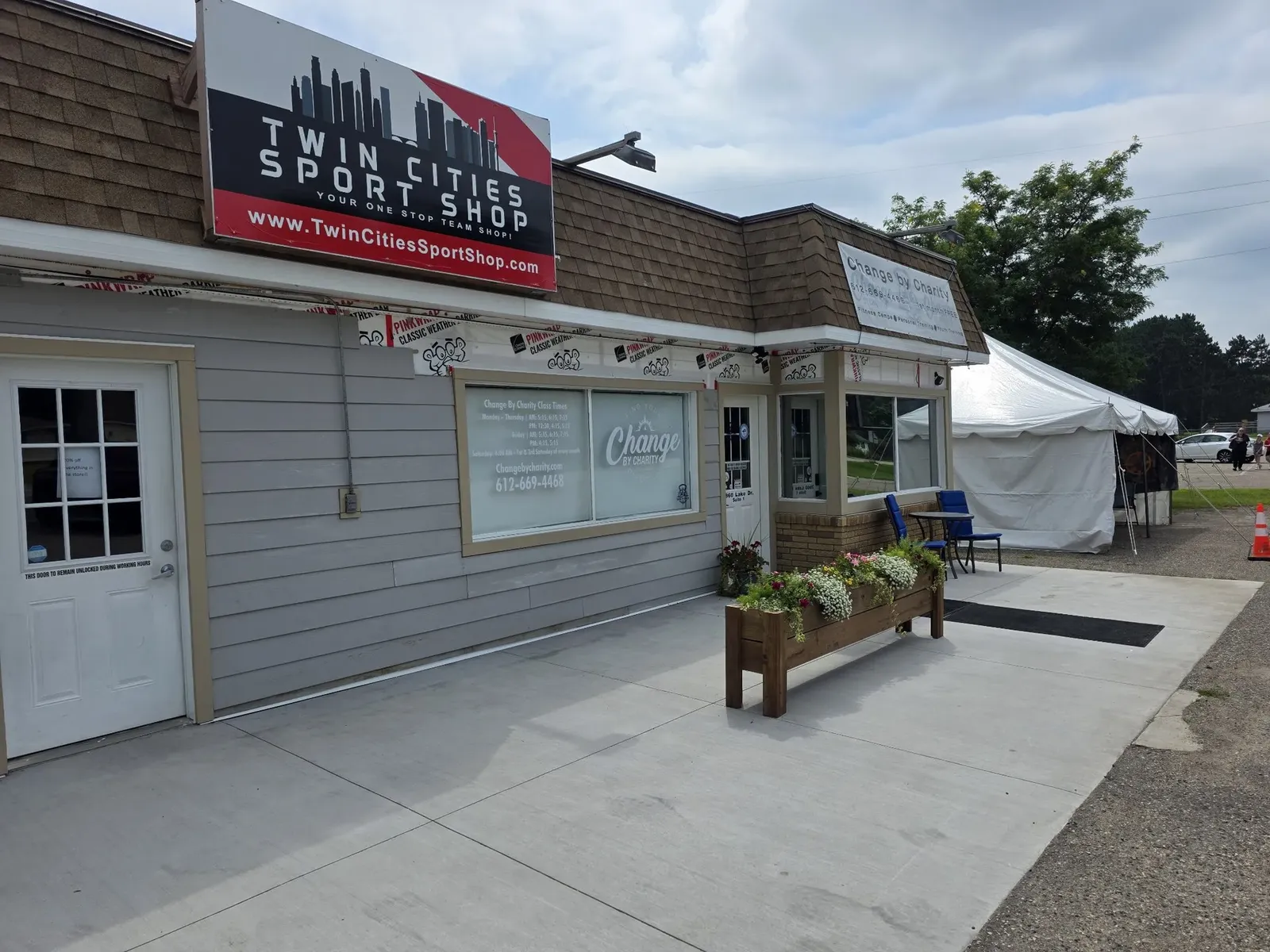 New gray siding beneath the Twin Cities Sport Shop sign, with the weather barrier still exposed along the top