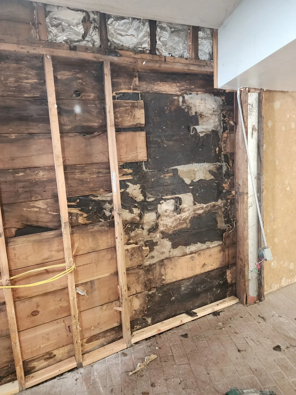 Water-damaged wall before repairs in the commercial gym