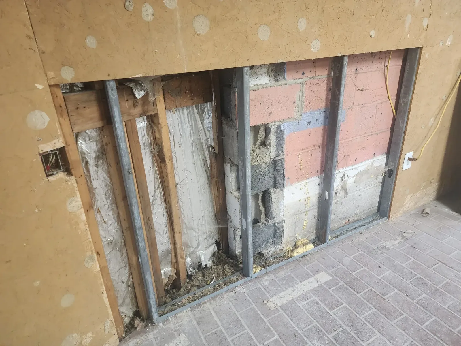 Interior wall stripped to exposed studs before rebuilding
