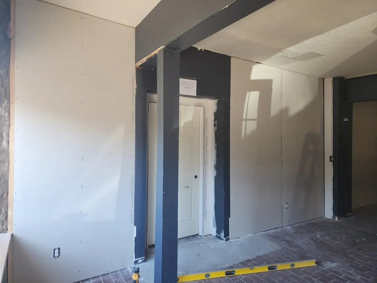Drywall panels hung on wood framing in a commercial gym