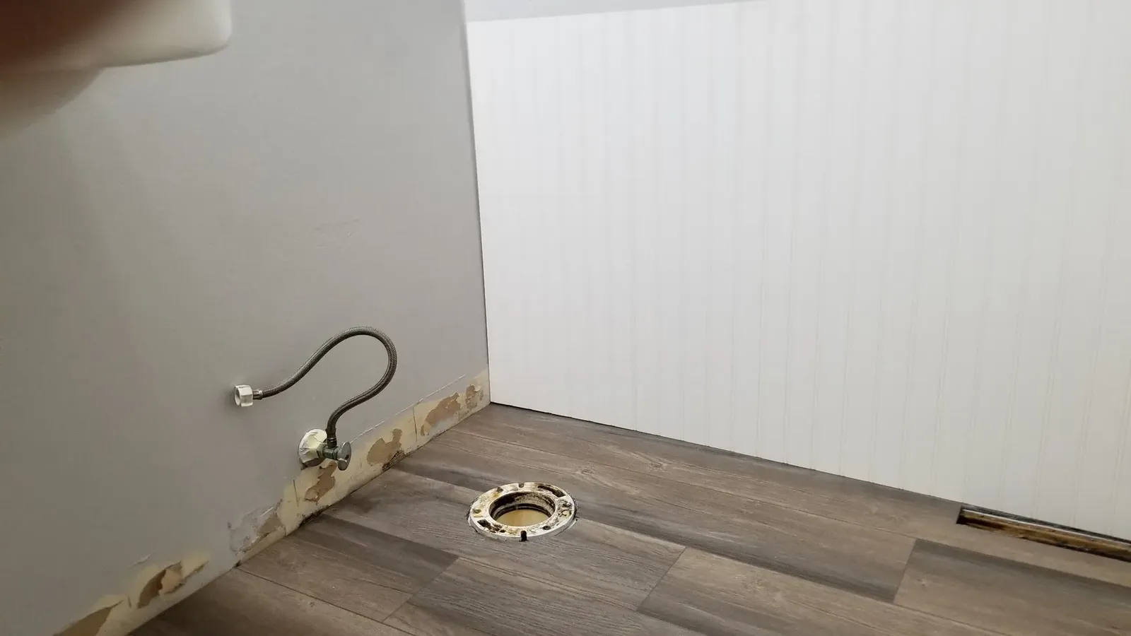Church powder room with the fixtures removed while beadboard wainscoting is installed