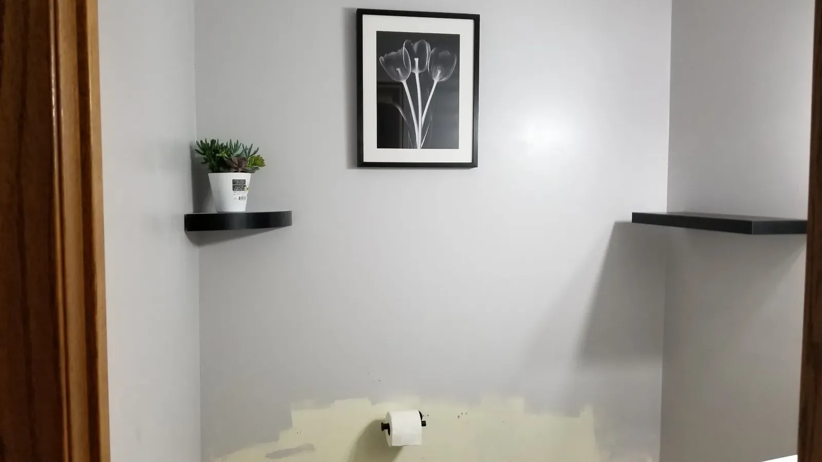 Floating wood shelves and decor above the powder room toilet