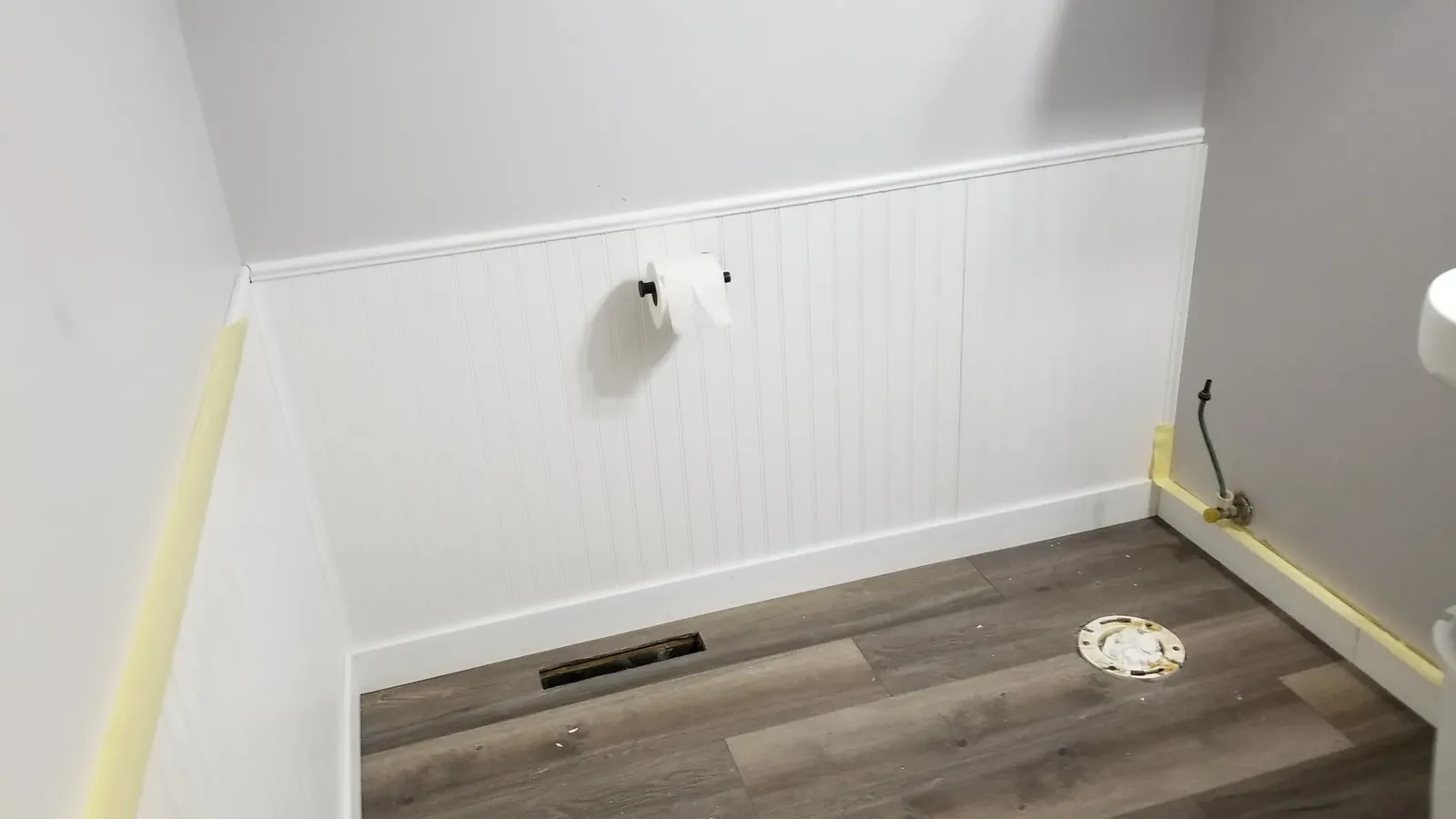 New beadboard wainscoting and flooring before the powder-room fixtures were reinstalled